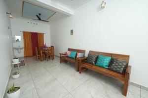 a living room with two benches and a table at VILLA MANTRAA in Varkala