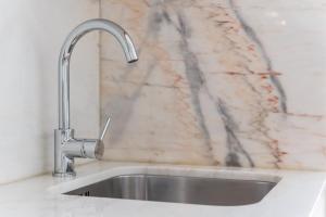 a stainless steel sink in a kitchen with a marble wall at GuestReady - Coral Apartment in Porto