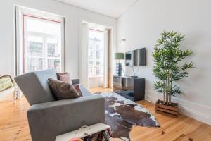 a living room with a couch and a potted plant at GuestReady - Coral Apartment in Porto