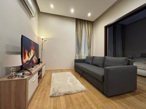 sala de estar con sofá y TV de pantalla plana en CORNER APARTMENT, en Budapest