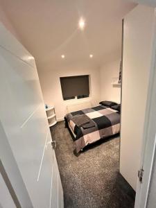 um quarto com uma cama e uma televisão de ecrã plano em Impeccable Holiday House in London Sleeps four em Londres