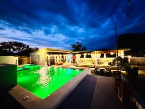 a swimming pool with green lighting in front of a house at Fredellio Farm and Resort in Anao