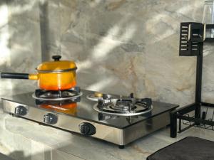 an orange pot on a stove in a kitchen at Fredellio Farm and Resort in Anao