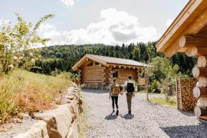 a man and woman walking down a gravel road towards a cabin at Jakob Chalets in Perasdorf