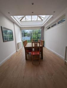 a dining room with a table and chairs and a skylight at Large 6 Bedroom house in Hendon in Hendon