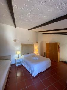 um quarto com uma grande cama branca e 2 candeeiros em Rabacal Hotel Suite B&B with pool em Chanca