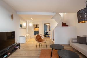 a living room with a couch and a table at L'antiquaire - 3 chambres - Hypercentre - Wifi in LʼIsle-sur-la-Sorgue