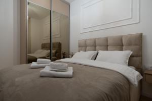 ein Schlafzimmer mit einem großen Bett mit zwei Handtüchern darauf in der Unterkunft City Luxury in Trebinje