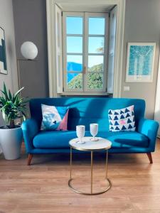 格里安泰卡德納比亞的住宿－CAPI SUITE，客厅配有一张蓝色的沙发,配有一张桌子
