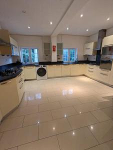 a large kitchen with white appliances and a tile floor at Large 6 Bedroom house in Hendon in Hendon