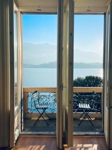 an open door to a balcony with a view of the water at CAPI SUITE in Griante Cadenabbia