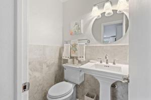 ベロビーチにあるBeautifully Renovated 5 bedroom Vero Beach homeの洗面台、トイレ、鏡のあるバスルーム