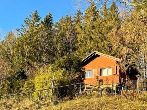 a small orange house in the middle of a field at Chalet Idylka in Saignelégier