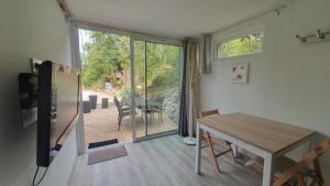 a dining room with a table and a sliding glass door at Lacustrebnb in Choisy