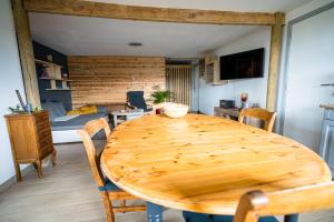 un comedor con una mesa de madera y un dormitorio en Appartement SPA VIP Pont Alsort en Froidchapelle