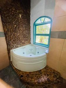 a bath tub in a bathroom with a window at Pousada e Hostel Vida no Paraiso in Angra dos Reis