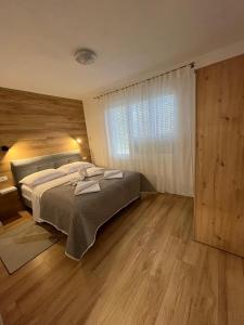 een slaapkamer met een groot bed en een groot raam bij Apartman TeNeN in Knin