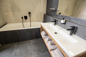 a bathroom with a sink and a bath tub at Hotel Kras in Jedovnice