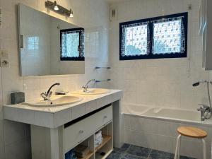 a bathroom with two sinks and a tub and a mirror at 305 - Belle maison à deux pas de l'Anse du Croc in Fréhel