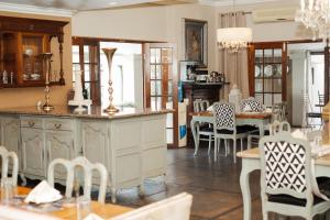 a kitchen and dining room with a table and chairs at Villa Brocant Guest house in Vryburg