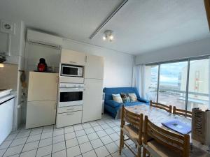 Una cocina y una sala de estar con un sofá y una mesa. en T2+cabine, clim, parking privé, 4 pers, Le Barcarès - FR-1-81-430, en Le Barcarès