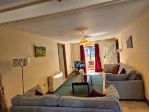 a living room with two couches and a table at Kestrel Farmhouse in Llandovery