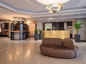 a lobby with a couch in the middle of a room at Dorint Hotel Würzburg in Würzburg
