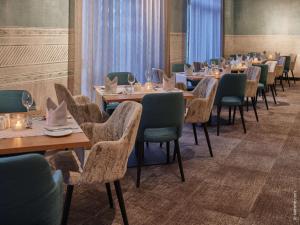 une rangée de tables et de chaises dans un restaurant dans l'établissement Dorint Hotel Würzburg, à Wurtzbourg