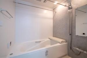 東京的住宿－オーシャンズスイート 東京ディズニーリゾートコージーバルコニー302，白色的浴室设有浴缸和淋浴。