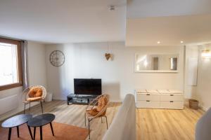un soggiorno con 2 sedie e una TV di L'antiquaire - 3 chambres - Hypercentre - Wifi a LʼIsle-sur-la-Sorgue