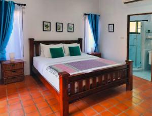 een slaapkamer met een houten bed met groene kussens bij 4 Bed Villa Private Pool and BBQ Jomtien Beach in Jomtien Beach