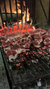 a bunch of meat is cooking on a grill at Affittacamere Pizzeria Ristorante Treppì in Caldiero