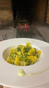 a bowl of pasta and broccoli on a plate with a spoon at Affittacamere Pizzeria Ristorante Treppì in Caldiero