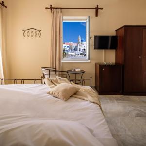 a bedroom with a large white bed with a window at Ikio Concept Santorini in Pyrgos