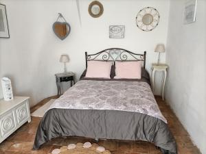 - une chambre avec un grand lit et des oreillers roses dans l'établissement Maison de la Tour, à Nant
