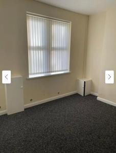 an empty room with two tables and a window at 29 ASHBURTON STREET in Stoke on Trent