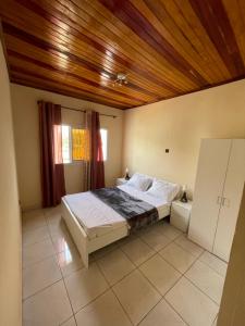 - une chambre avec un lit et un plafond en bois dans l'établissement Appartement Aachen, à Yaoundé