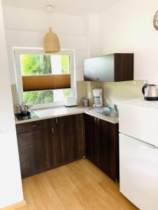 uma cozinha com armários de madeira e uma janela em Pod Lipami em Lubiatowo