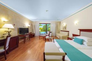 een hotelkamer met een groot bed en een televisie bij Atrium Palace Thalasso Spa Resort And Villas in Kalathos