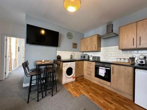 a kitchen with a washer and dryer and a table at Land Of Green Ginger Apartment- City Centre in Hull +8 photos