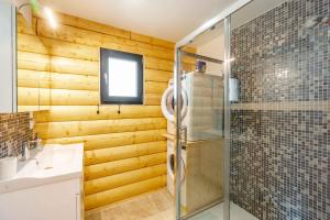 a bathroom with wooden walls and a glass shower at Chalet Agréable 3 étoiles app 4 in Courchevel +9 photos