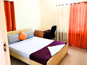 1 dormitorio con 1 cama y escritorio con silla en Golden Magnolia Homestay en Bangalore