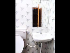 biała łazienka z toaletą i umywalką w obiekcie Golden Magnolia Homestay w mieście Bengaluru