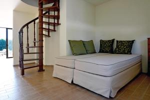 a couch in a living room with a spiral staircase at Holiday Village - Swimming pool apartments in Kamena Vourla