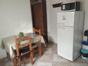 a table with a chair and a microwave on top of a refrigerator at DonAldo Dto in Ushuaia