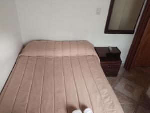 Bett in einem Zimmer mit einem Bettröckchen in der Unterkunft DonAldo in Ushuaia