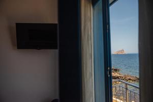 a room with a window with a view of the ocean at La terrazza del sole “ apartments “ in Marettimo
