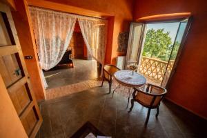 Habitación con mesa, sillas y ventana en Agriturismo Fonte di Maroglio, en Castrovillari