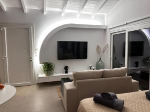 a living room with a couch and a flat screen tv at Grande Terra Villas with Swimming Pool & Starlink WiFi in Spartýlas +122 photos