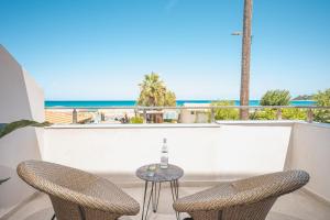 阿里克斯Palm Tree Beach Suites, by ZanteWize的海滩阳台的一张桌子和两把椅子